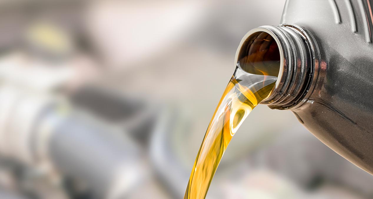 Botella vertiendo aceite para motor de auto